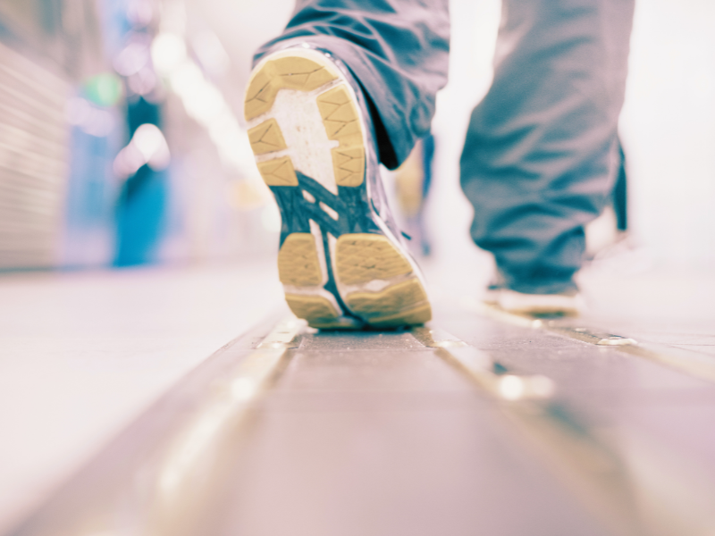 工場の通路を歩く人の足元をクローズアップした写真。